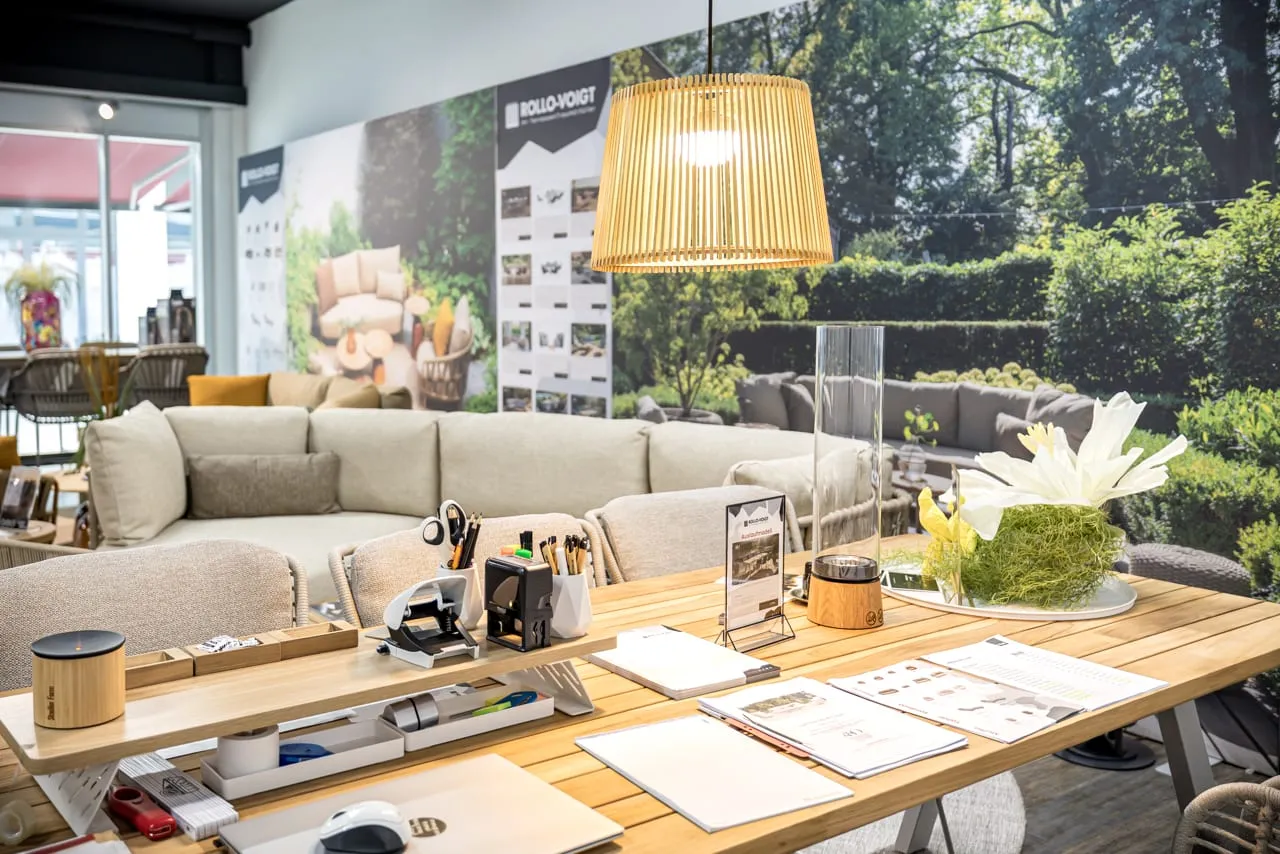 Planungstisch mit Katalogen und Mustern unter warmer Pendelleuchte