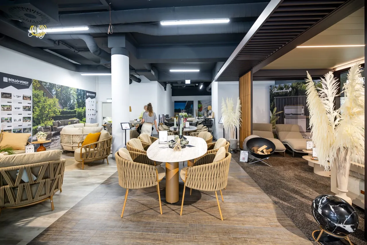 Blick durch den Pop-up-Store: Dining-Set unter der Pergola, Lounge-Bereiche und Pampasgras-Dekoration