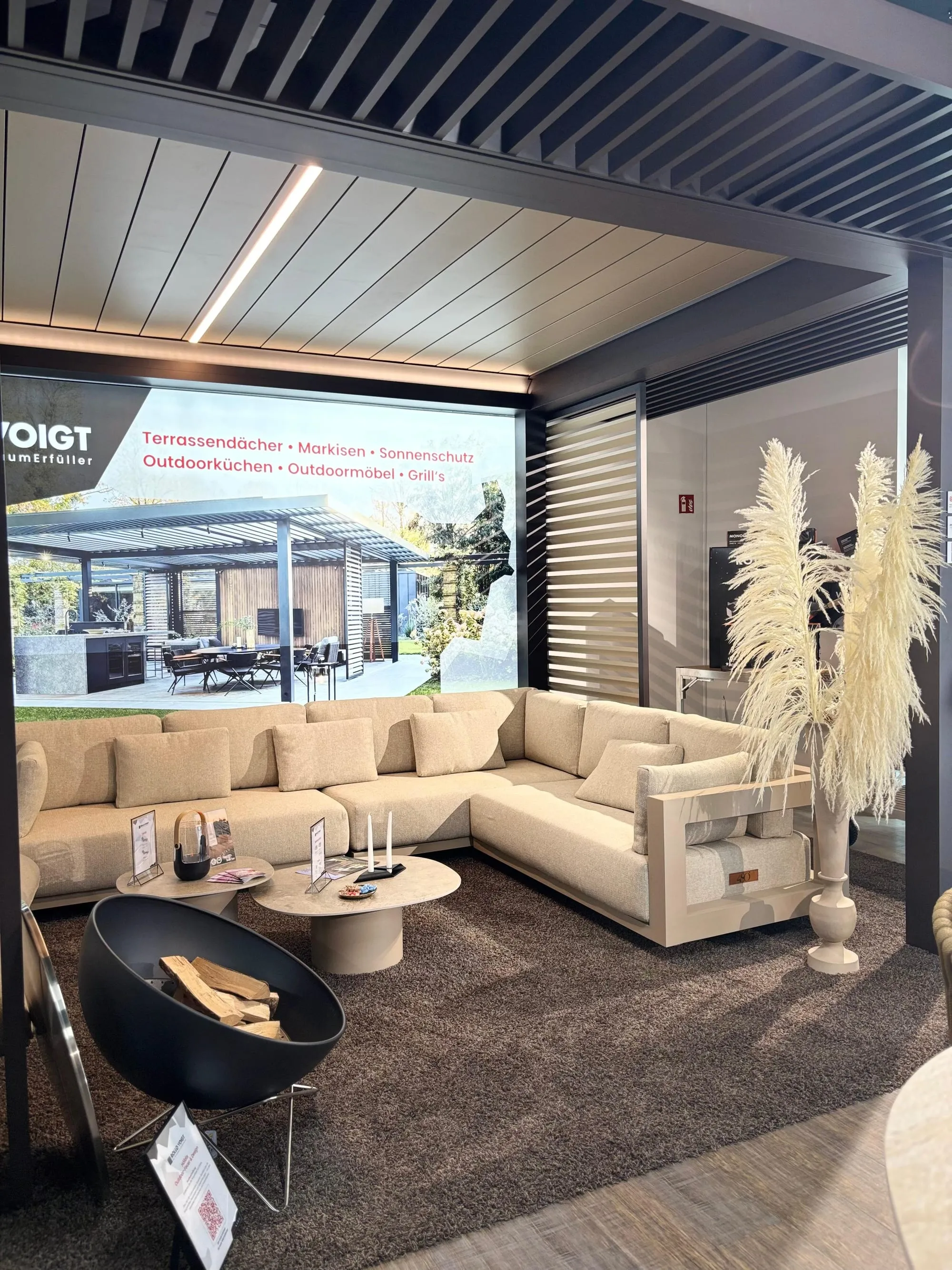 Übersicht im Pop-up-Store: Dining-Tisch mit Blumenstrauß, Lounge-Ecke und Rollo-Voigt-Wandbild